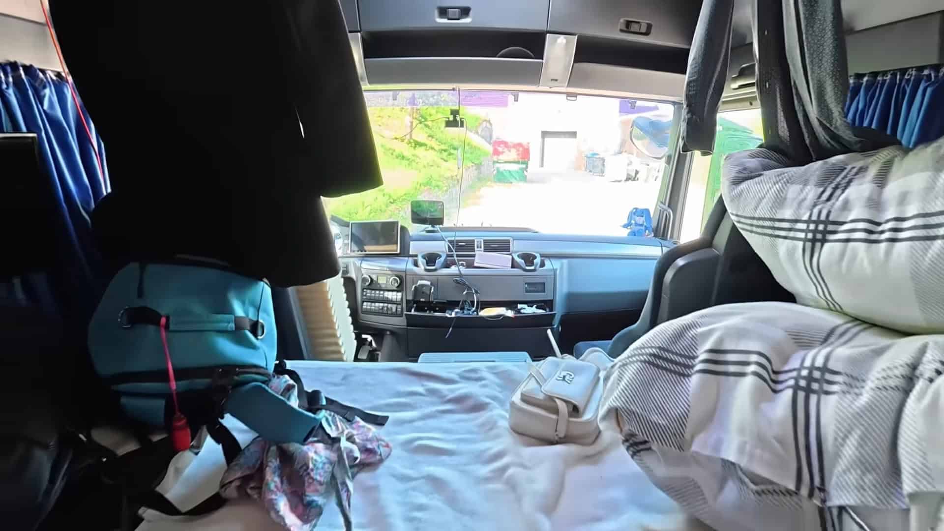 Full-size sleeper bed behind the cockpit in the MAN truck cab serving as a second bedroom
