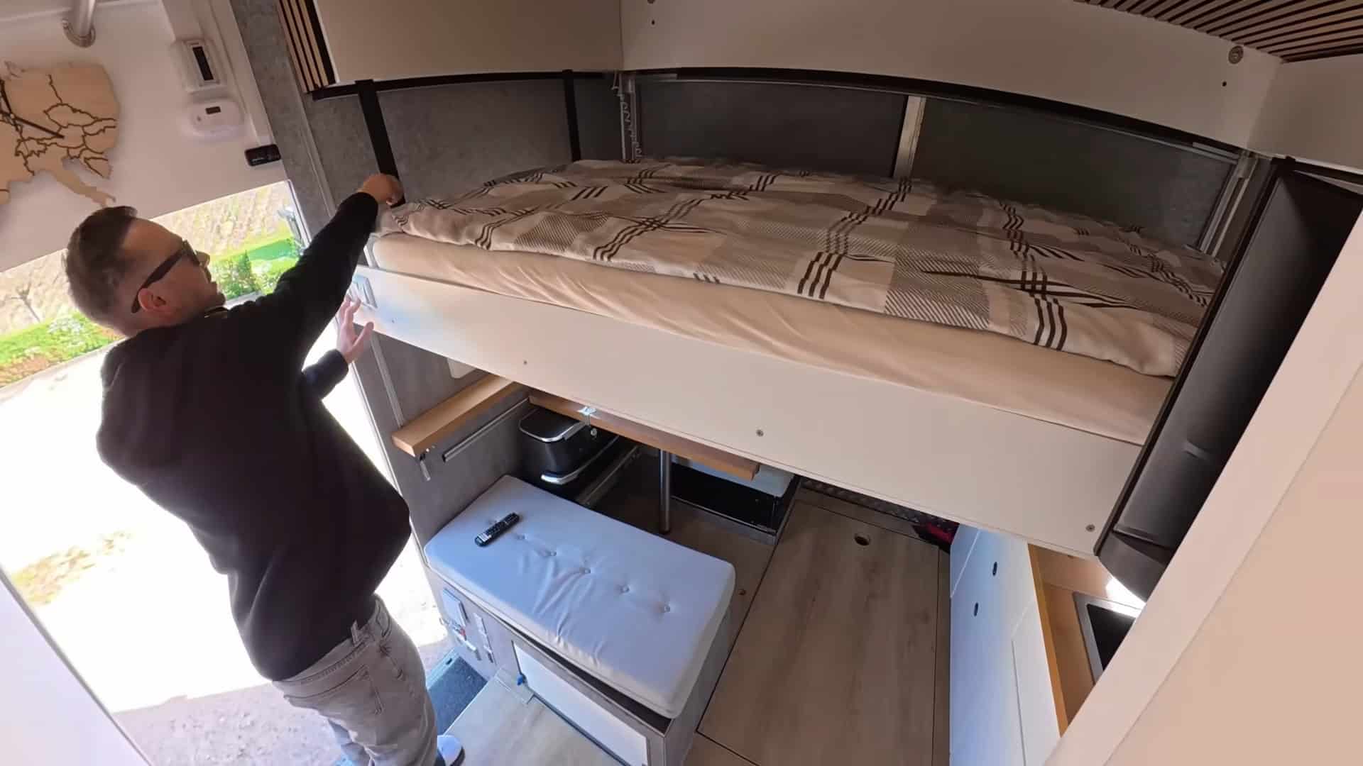 Motorized elevator bed lowered to sleeping position in the DIY semi-truck tiny house