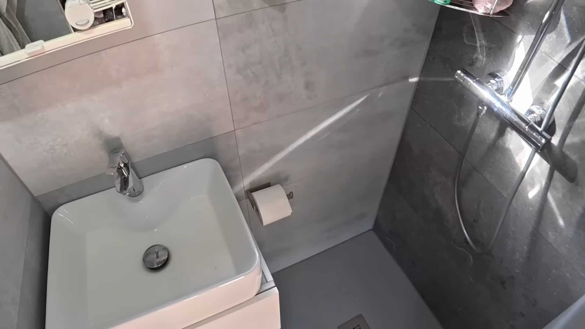 Stone shower tray and sink in the bathroom of the DIY semi-truck tiny house conversion
