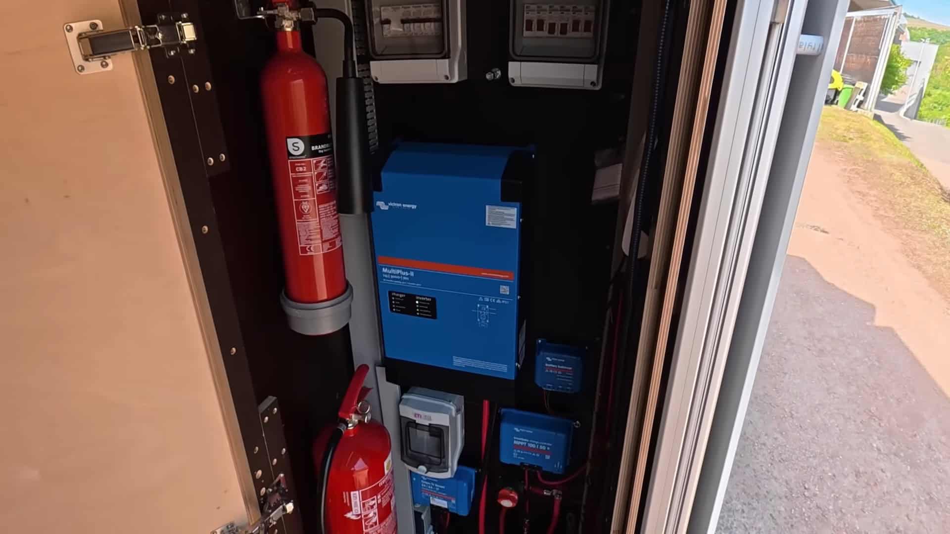 Victron MultiPlus-II inverter and electrical panel with fire extinguishers in the truck camper