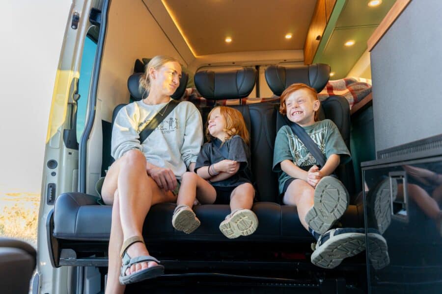 Family enjoying a cozy van conversion for travel adventures.