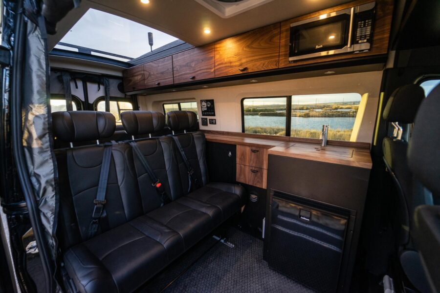 Interior view of a family van conversion with comfortable seating and modern amenities.