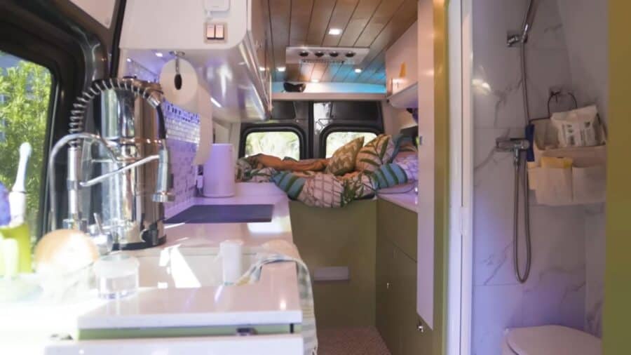 Cozy tiny house interior featuring a wet bath and compact kitchen setup.
