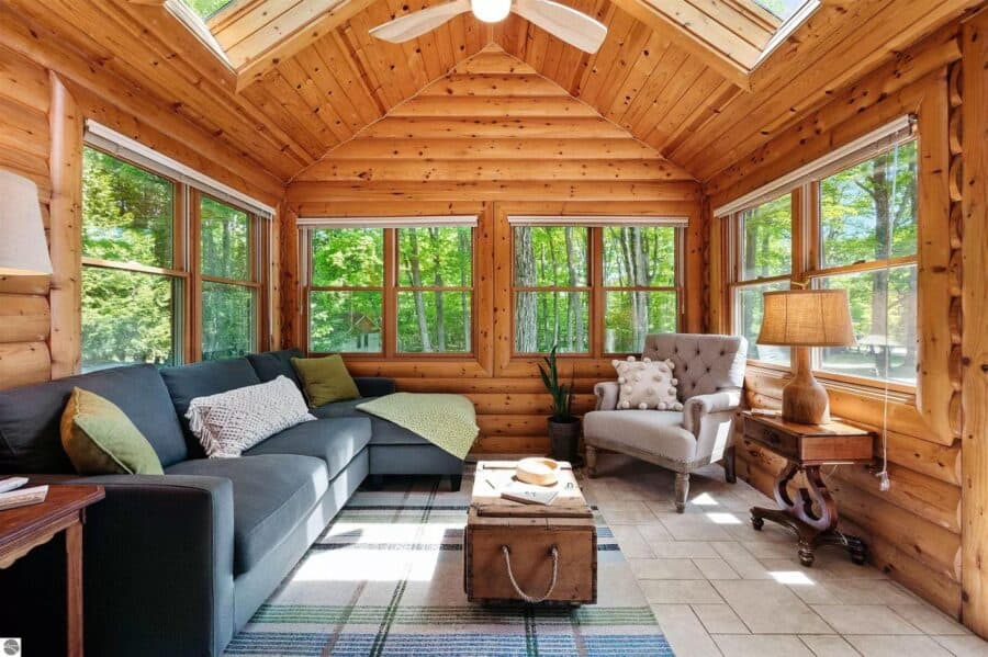 Cozy wooden interior living room with large windows and comfortable furniture in a tiny house.