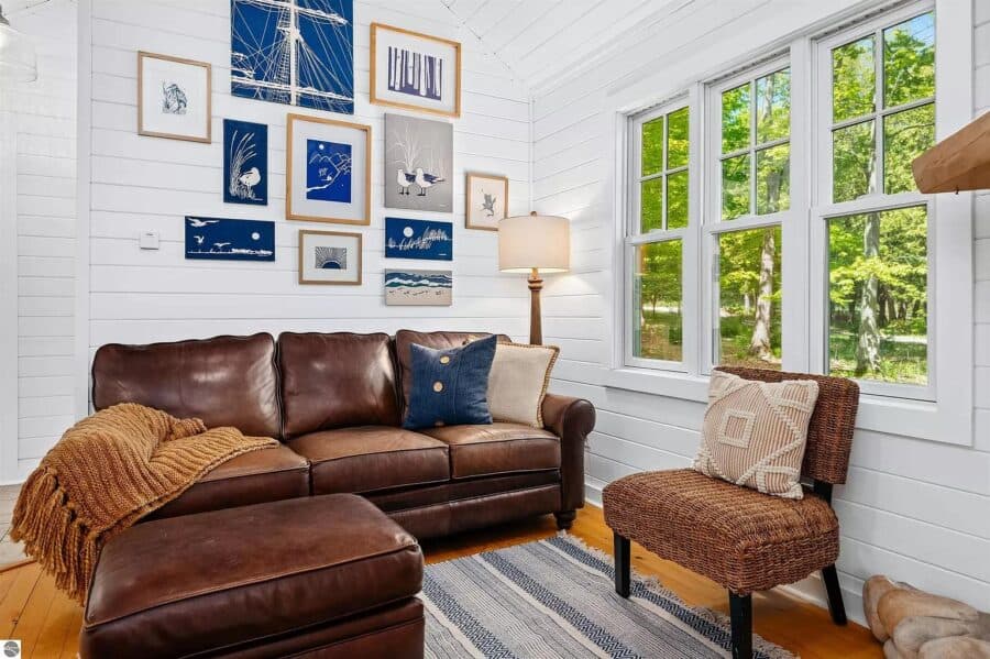 Charming log cabin interior with white walls, large windows, and comfortable seating in Northern Mic.