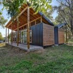 Shipping container tiny house with modern design and outdoor deck in Brenham, Texas.