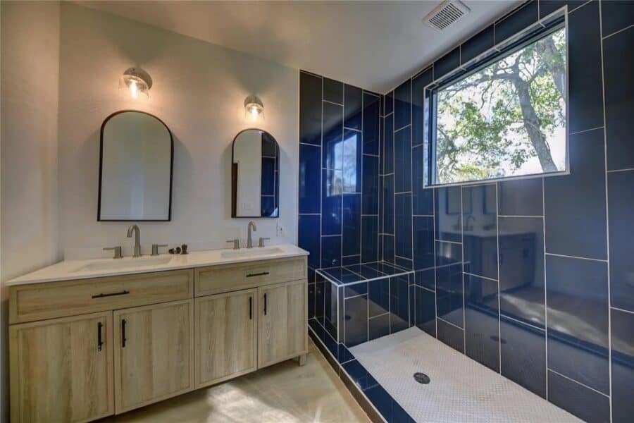 Modern bathroom inside a tiny house with sleek blue tiles and minimalist fixtures.