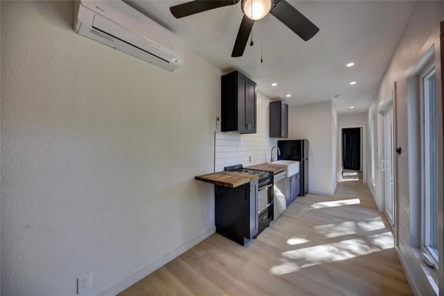Modern shipping container home interior with compact kitchen and bright natural light.