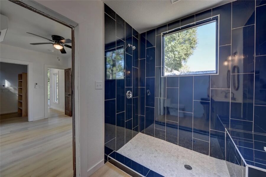 Modern blue-tiled shower in a compact tiny house bathroom.