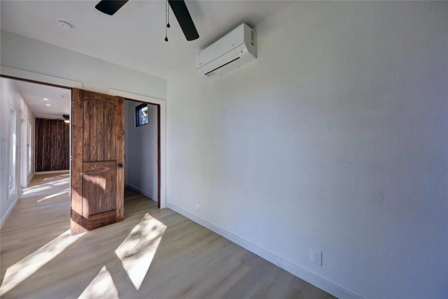 Bright, open space inside a tiny house with white walls and wooden accents.
