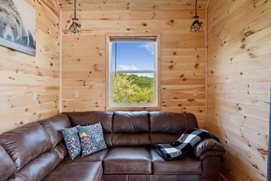Interior of Eagles Nest Cabin in West Virginia with wooden walls and a view of nature.