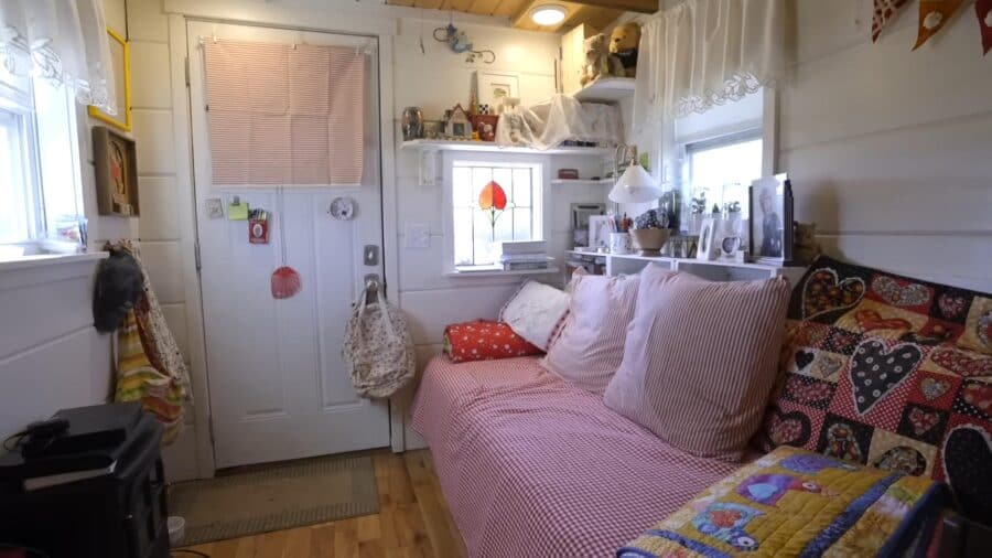 Interior of a small, charming tiny house with cozy furnishings and natural light.