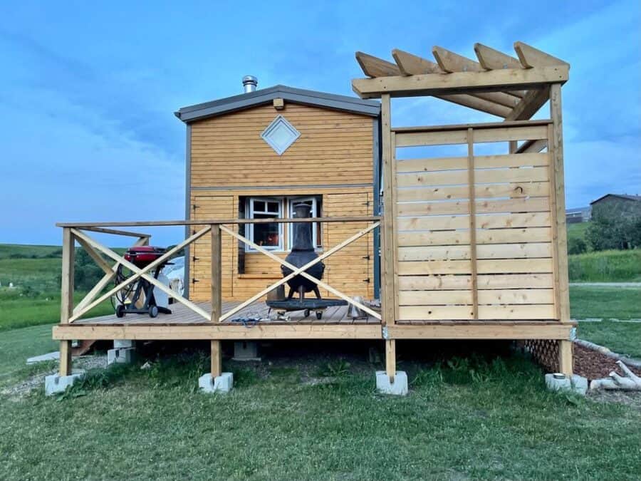 Eco-Bohemian tiny house with a spacious deck and handcrafted wooden exterior.