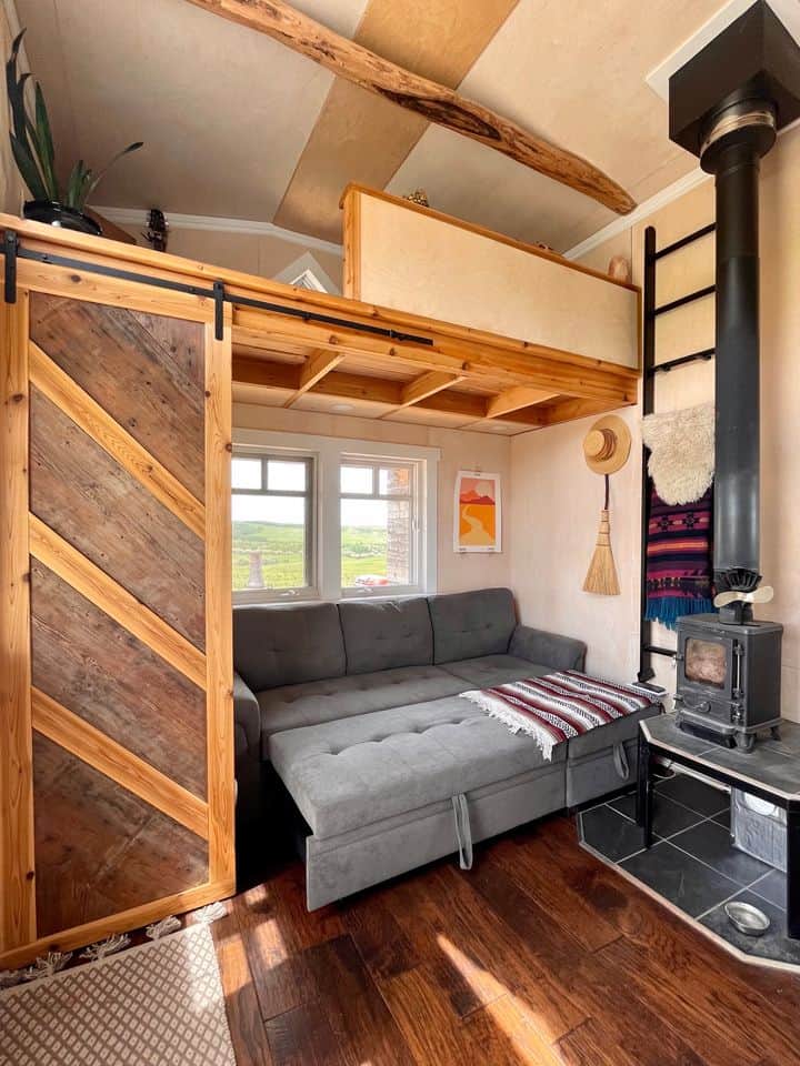 Handcrafted eco-bohemian tiny house interior with a cozy living space and wood accents.