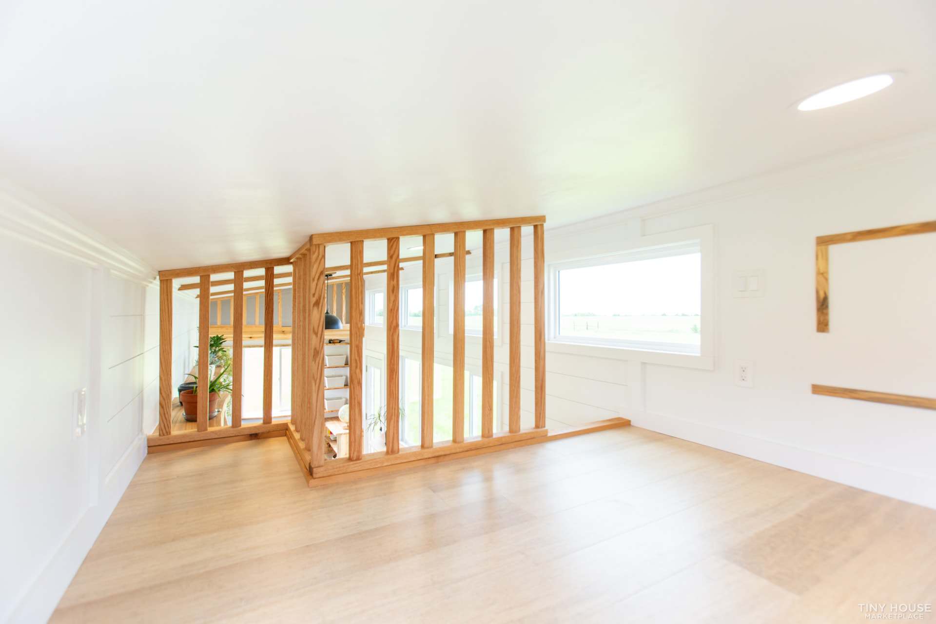 Floor-to-ceiling oak slat railing at the edge of the Elderberry's main sleeping loft