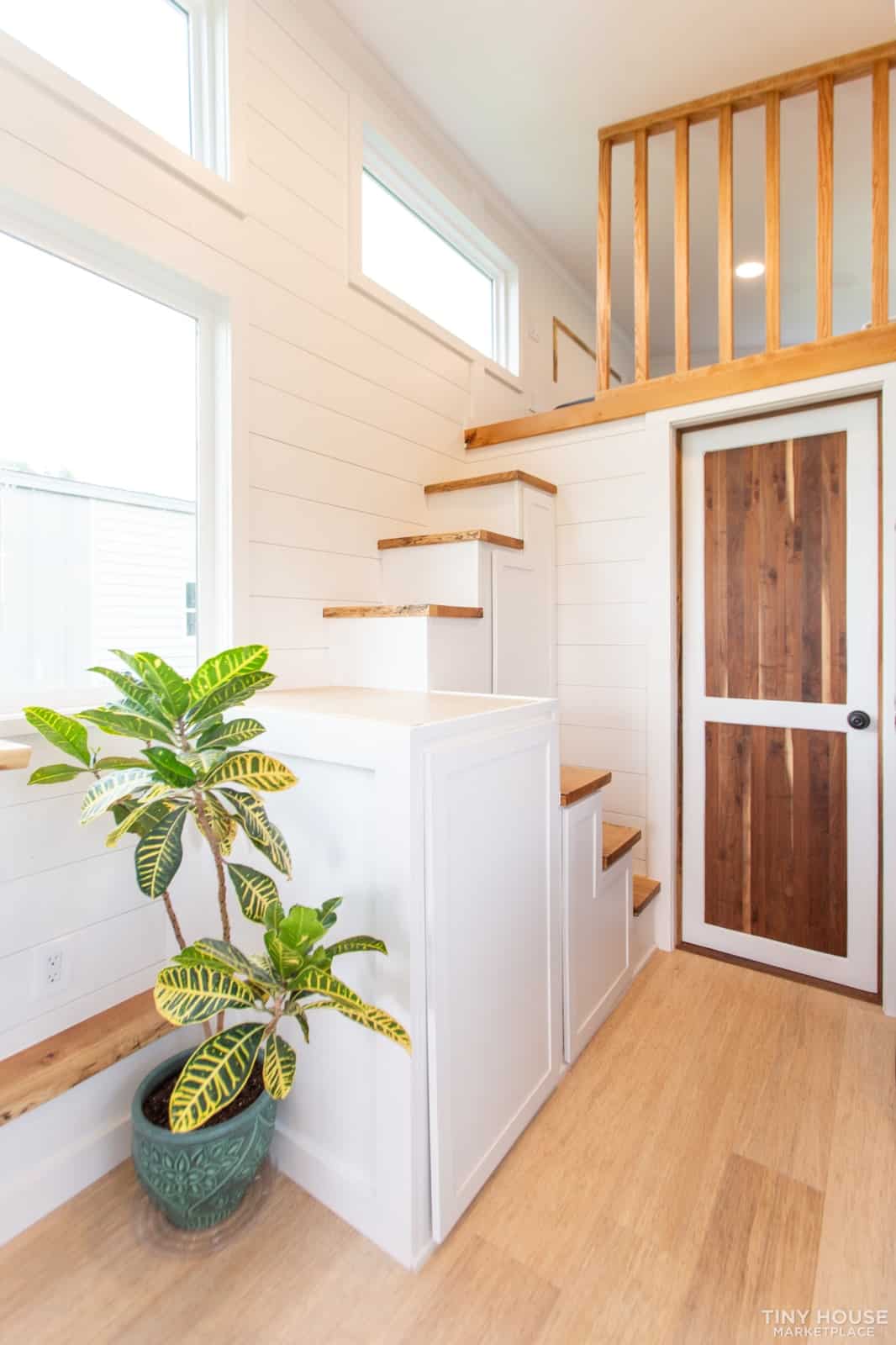 Oak-topped switchback staircase leading to the Elderberry loft, beside the walnut-accented bathroom door