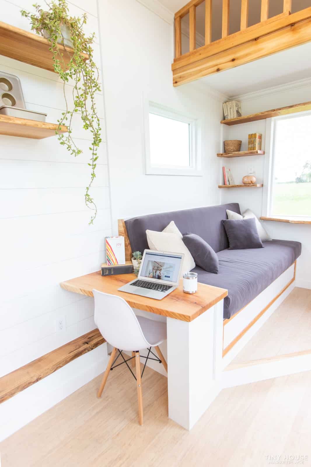 Attached oak work desk with a white chair and laptop next to the couch in the Elderberry living room