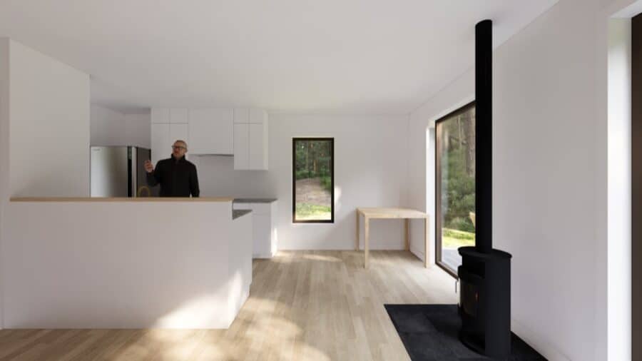 Interior view of the Bosun Cabin tiny home with minimalist decor and a wood stove.