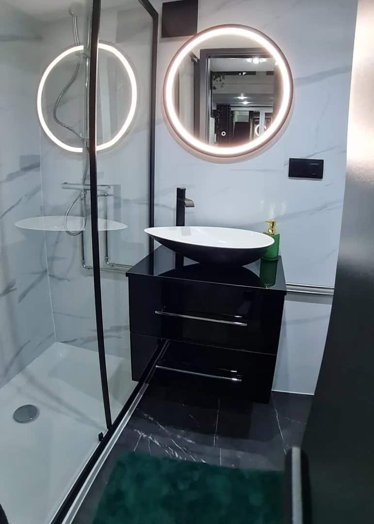 Bathroom in the dark Erica build with a black gloss vanity, vessel sink, and round LED mirror