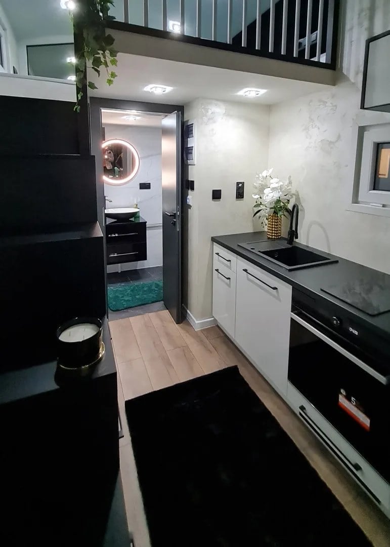 Dark-build Erica kitchen with white cabinets, a black countertop, and an induction hob