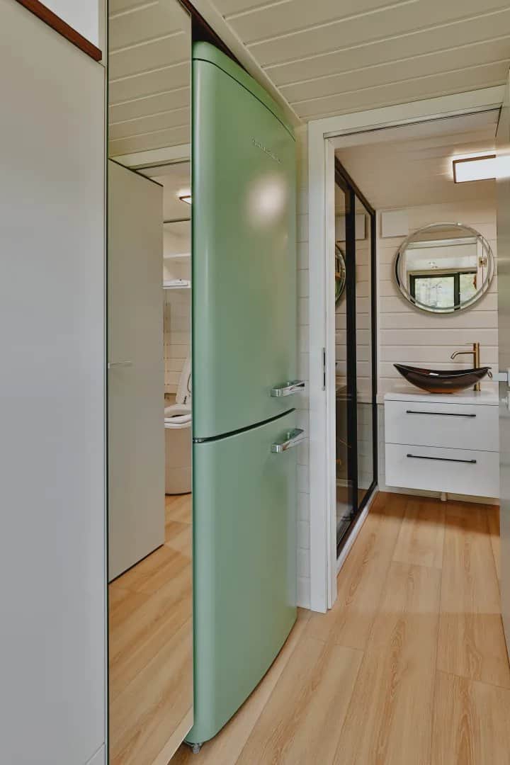 Scandinavian Erica interior with a mint retro refrigerator, rope loft railing, and a porthole window