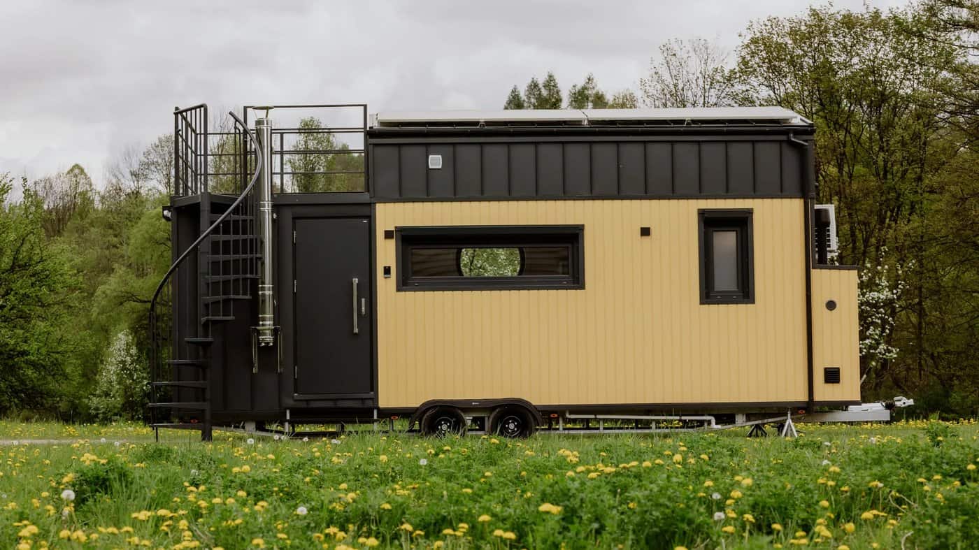 Side view of the yellow Scandinavian Erica build with a rooftop terrace in a meadow
