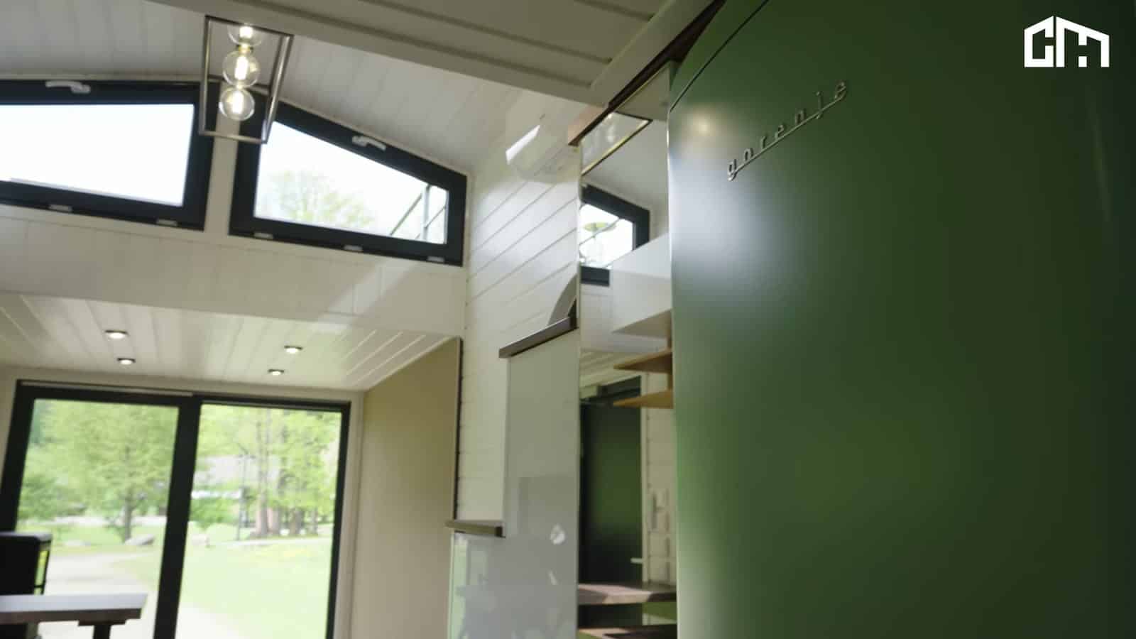 Looking up from the living area of the Erica toward the mezzanine clerestory windows, with the green fridge and sliding glass doors below