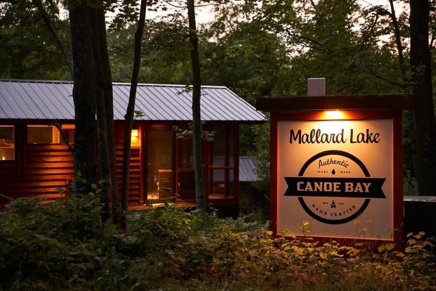 A small, charming tiny house nestled among trees at Mallard Lake, perfect for a peaceful retreat.