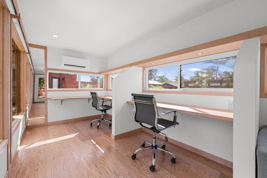 Upstairs loft of the Traveler XLS Wide set up as a two-desk home office with office chairs, windows, and a mini-split.