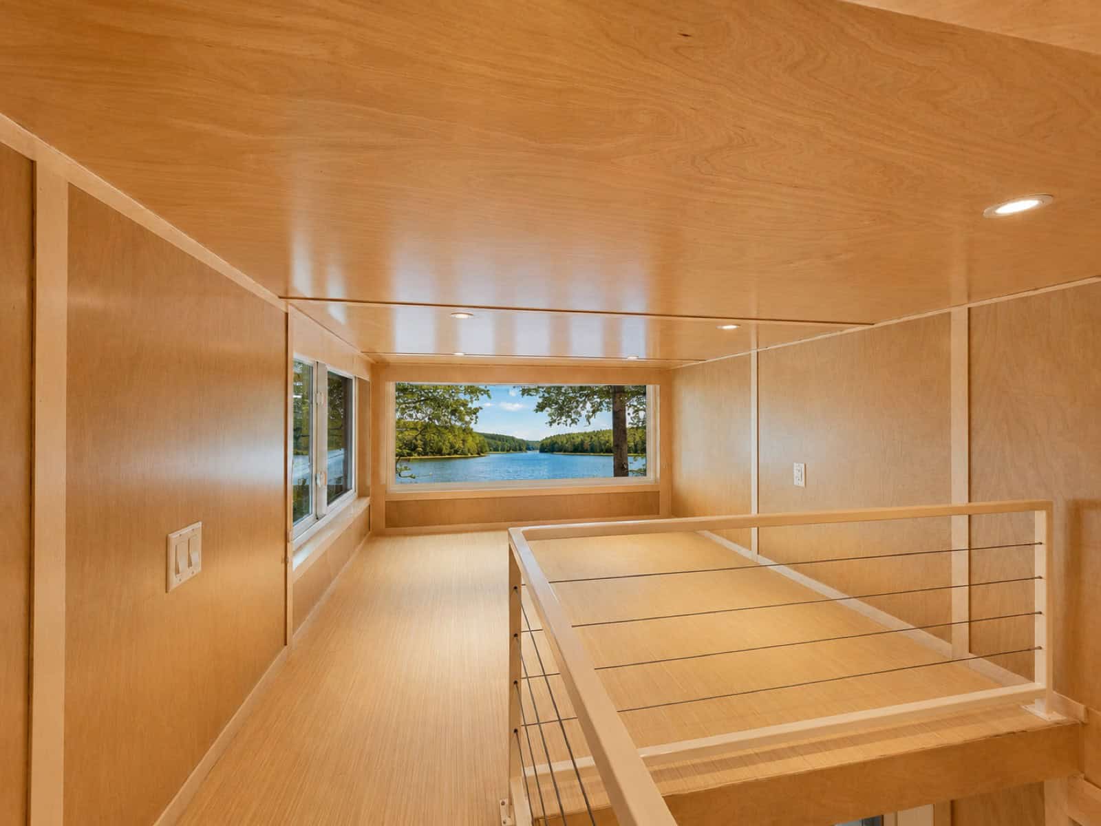 Upper floor room in the Escape eONE Limited Edition with a long window band framing a lake view