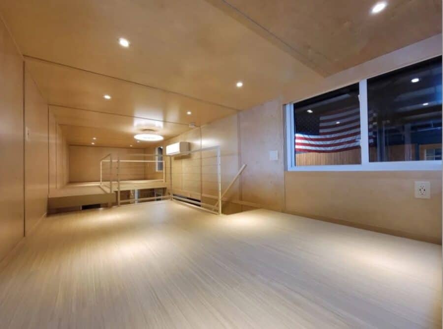 Modern tiny house interior with sleek wood finishes and large window for natural light.