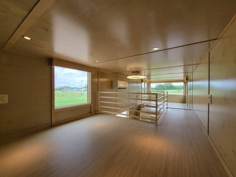 Bright tiny house interior showcasing spacious design and natural light from large windows.