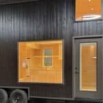 Compact tiny house on wheels with modern black exterior and large window. Perfect for small space li.