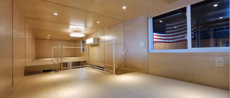 Modern tiny house interior with spacious, minimalist design and large window.