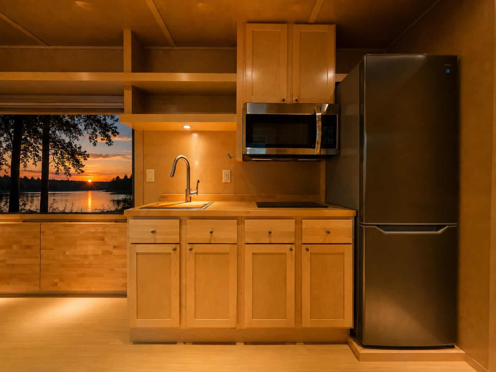 Maple kitchen in the Escape eVista with butcher block counters, microwave and tall refrigerator freezer