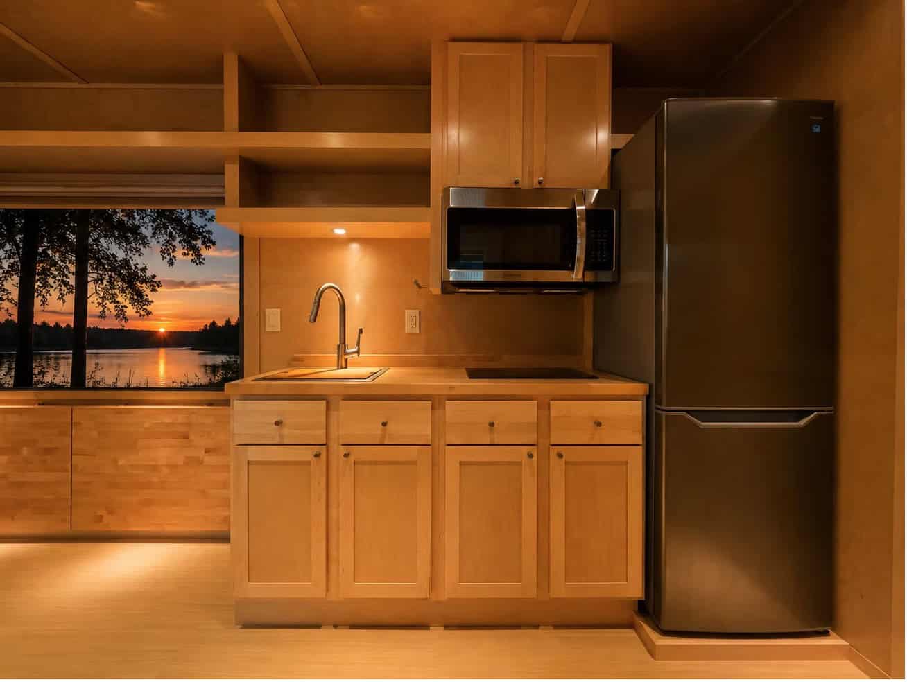 Escape eVista kitchen with maple cabinets, stainless microwave, induction cooktop and tall refrigerator
