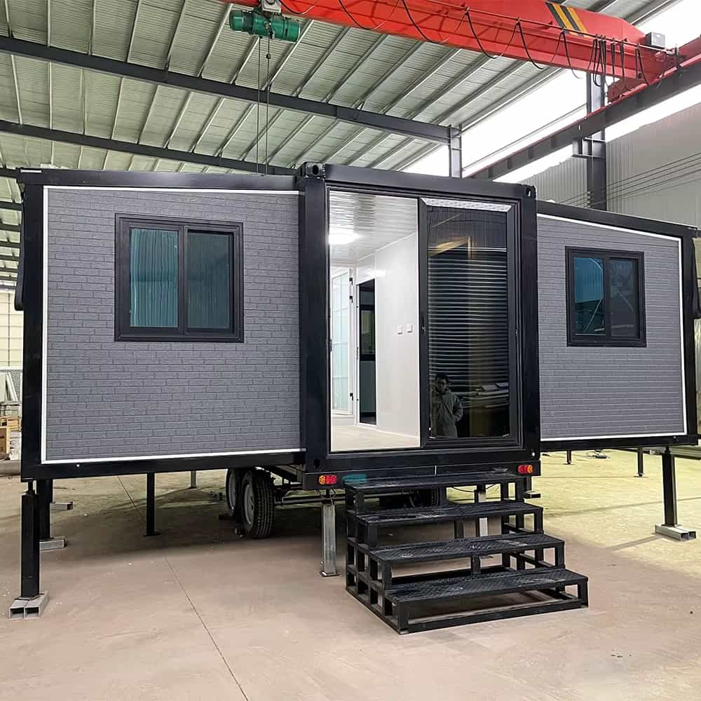 Modern tiny house on wheels with black exterior and large glass door.