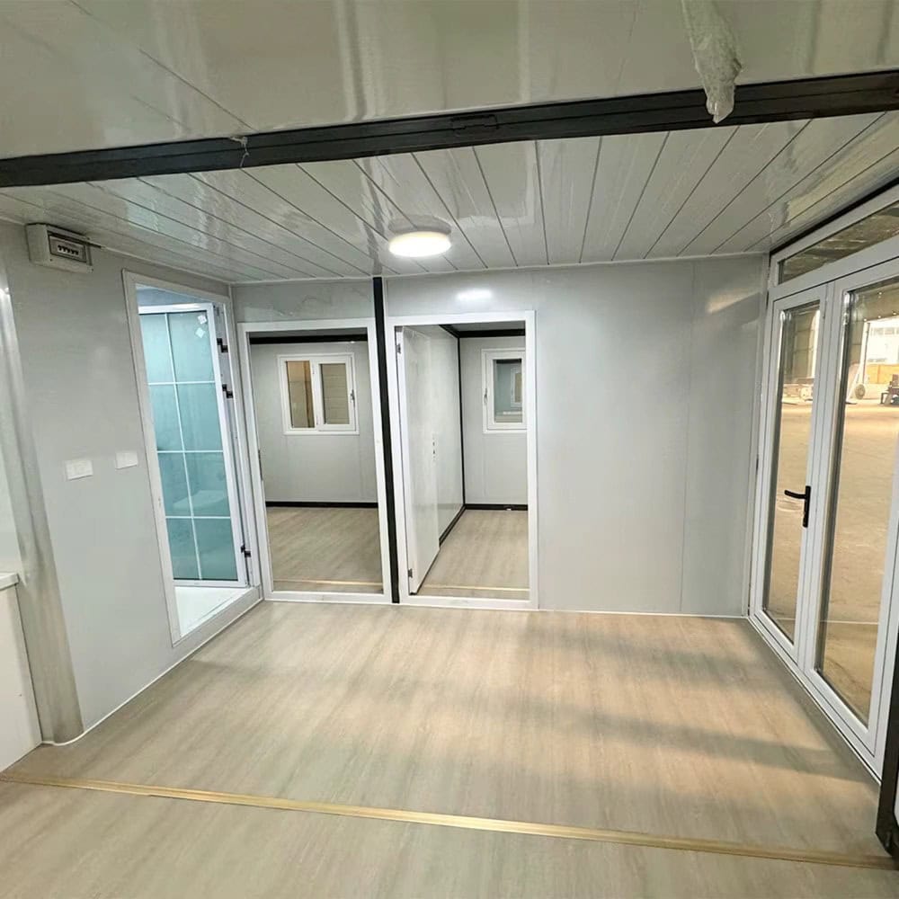 Modern tiny house interior with sliding glass doors and light wood flooring.
