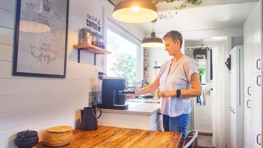 Woman preparing coffee in a cozy tiny house kitchen in Australia.