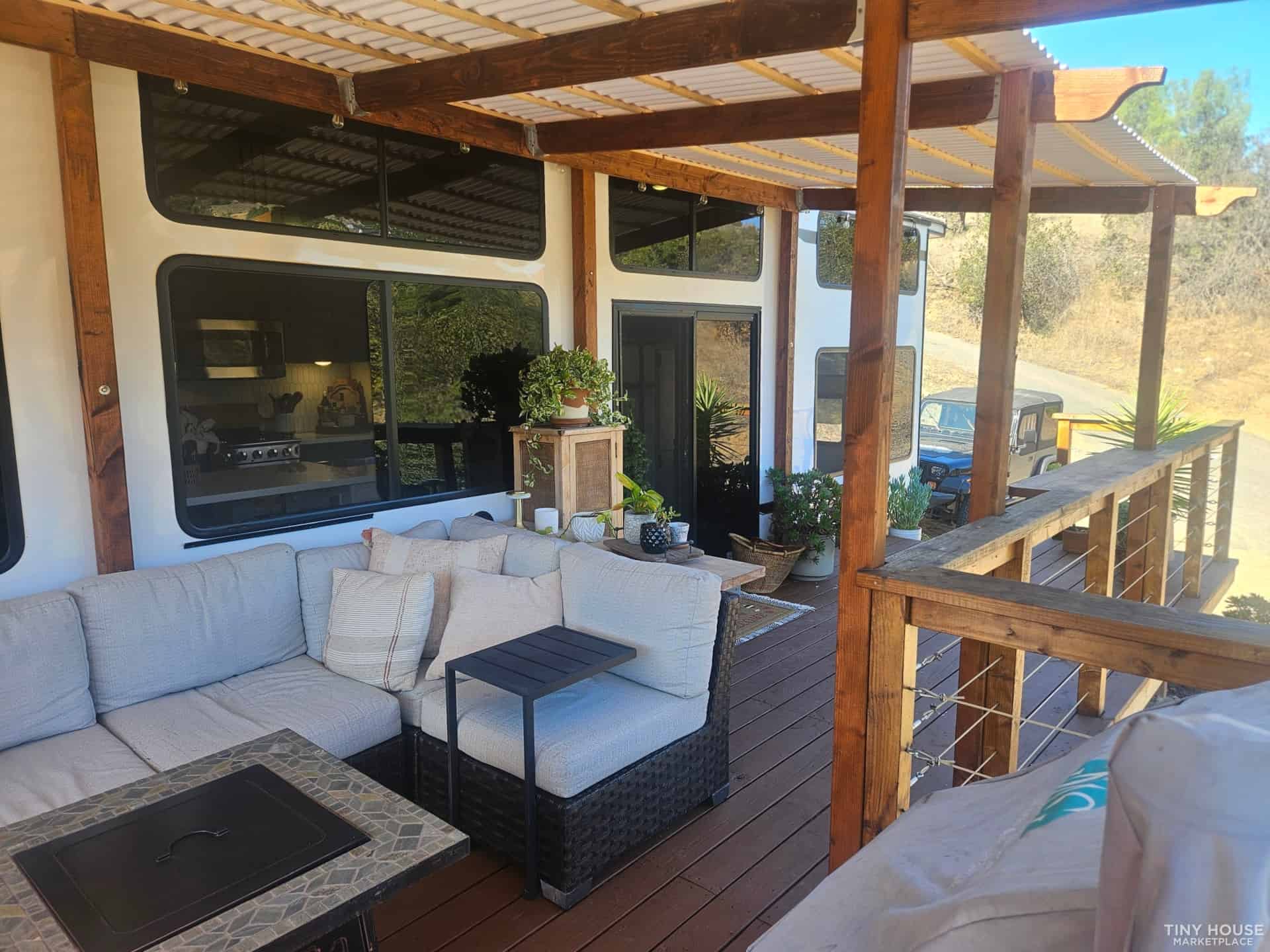 Outdoor porch with cozy seating area and wooden deck in tiny house setting.