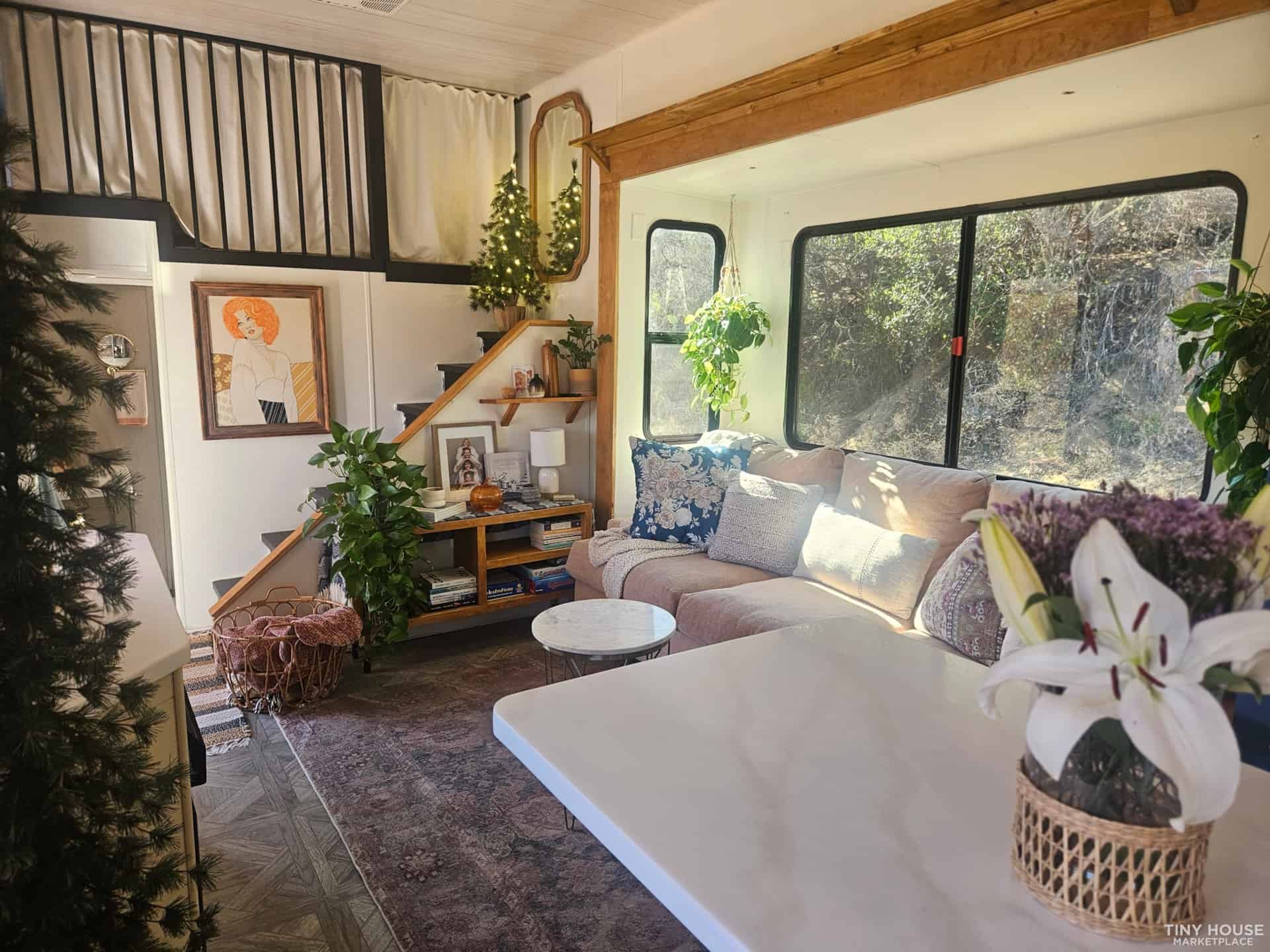 Bright and inviting tiny house interior with large windows and comfortable seating.