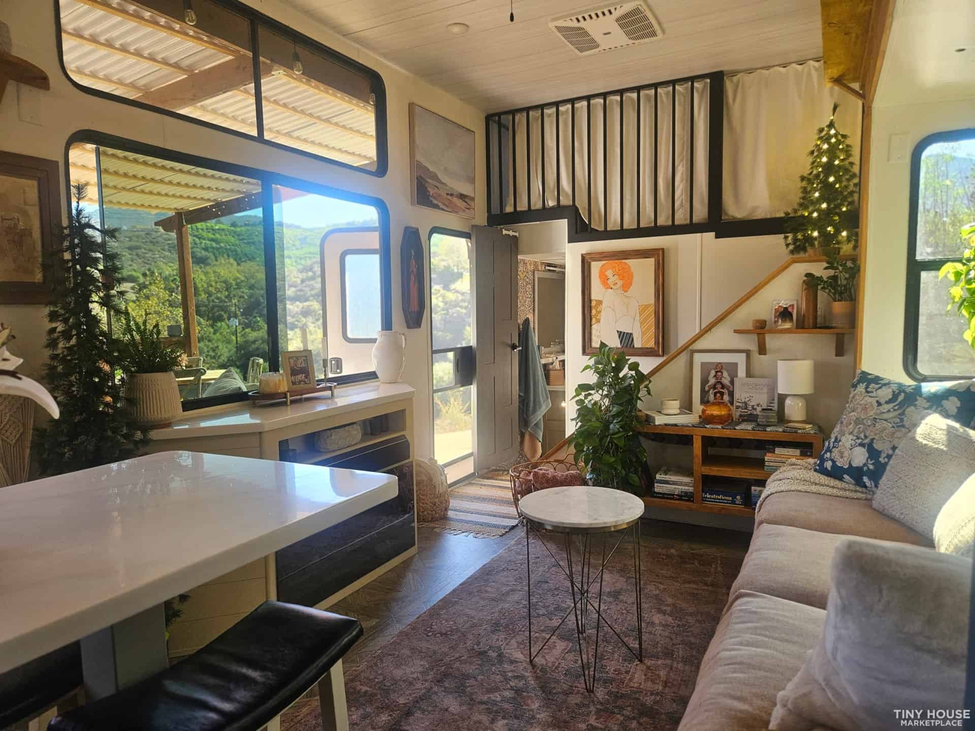 Bright and inviting tiny house interior with large windows and modern decor.