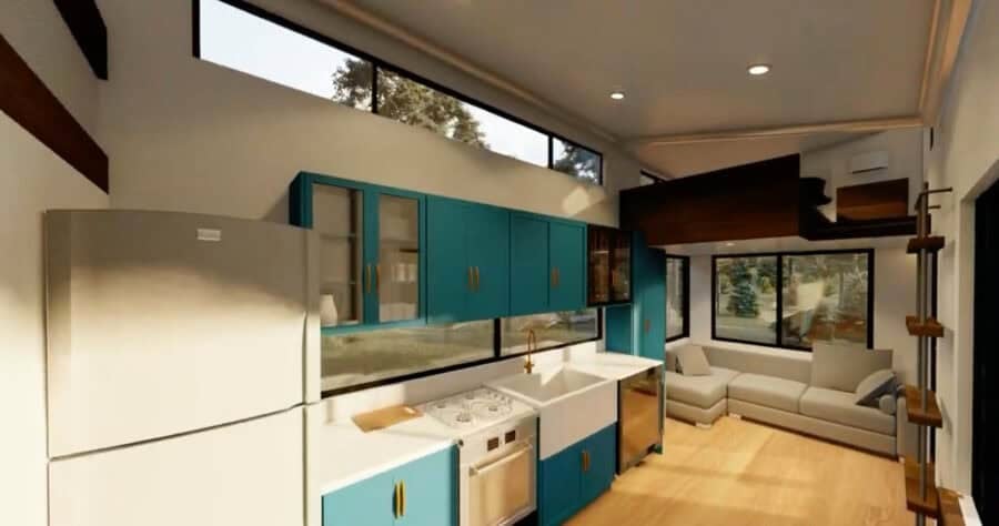 Modern tiny house kitchen with blue cabinets and open living space.