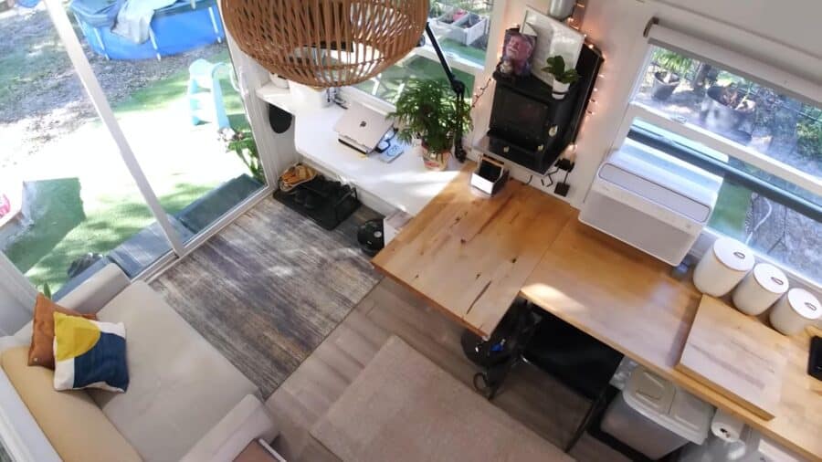 Compact tiny house interior with cozy living space and workspace for travel adventures.