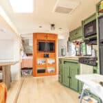 Interior of a family of 5 in a 28 ft. RV conversion with compact kitchen and living space.