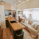 Bright tiny house interior with open kitchen and comfortable seating area.