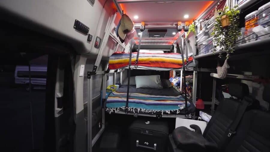 Cozy tiny house interior featuring bunk beds, storage solutions, and ambient lighting for small spac.