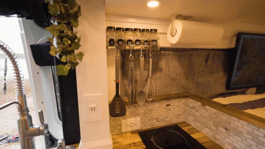 Compact tiny house kitchen with organized utensils and storage solutions.