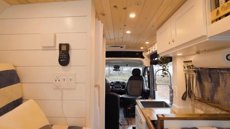 Interior of a tiny house van conversion with compact kitchen and cozy seating area.