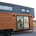 Felicity tiny house featuring modern design, connecting lofts, and large windows for small space fre.